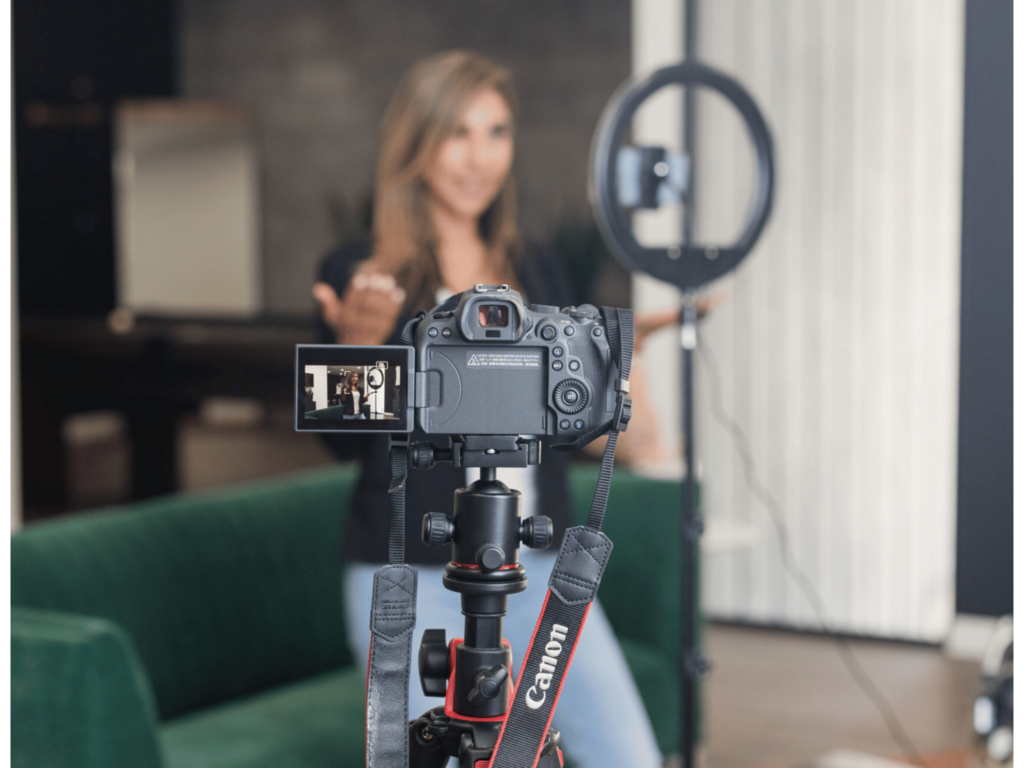 Woman filming Content with dslr camera and ring light in business casual